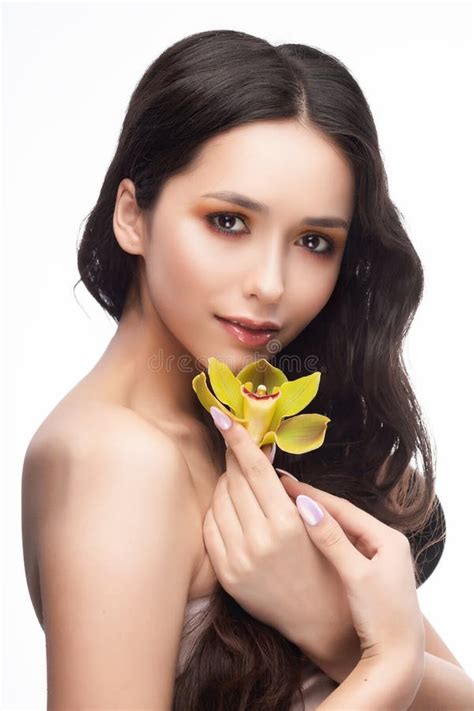 Uma Menina Moreno Bonita Dos Ombros Do Nude Guarda Sensualmente Um Flowe Imagem De Stock