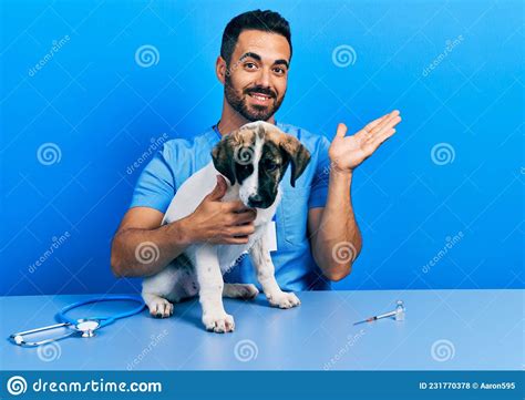 Handsome Hispanic Veterinary Man With Beard Checking Dog Health Smiling