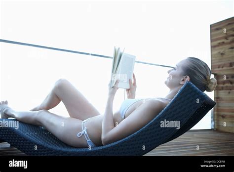 A Lady In Bikini Reading A Book While Lying On A Beach Bed Stock Photo Alamy