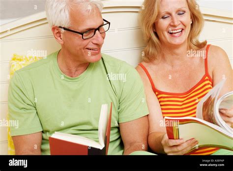 Close Up Of A Mature Couple Sitting On The Bed And Smiling Stock Photo Alamy