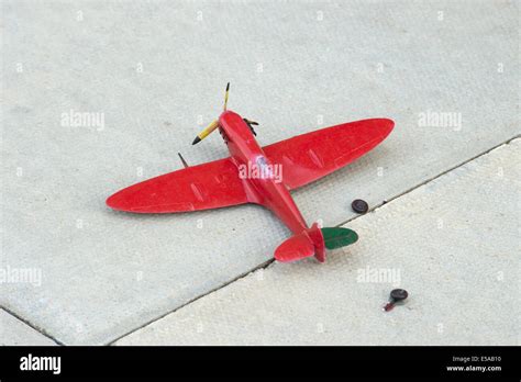 Broken Red Toy Spitfire Aeroplane Aircraft Discard Paving Slab