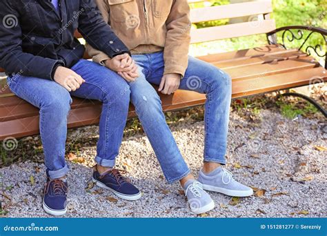Happy Gay Couple Holding Hands While Sitting On Bench In Park Stock Image Image Of
