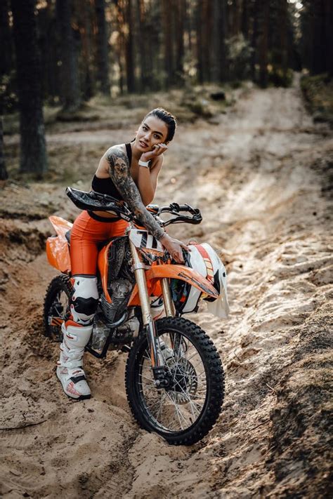 Female Racer Wearing Motocross Outfit With Semi Naked Torso Sitting On Her Bike In The Forest