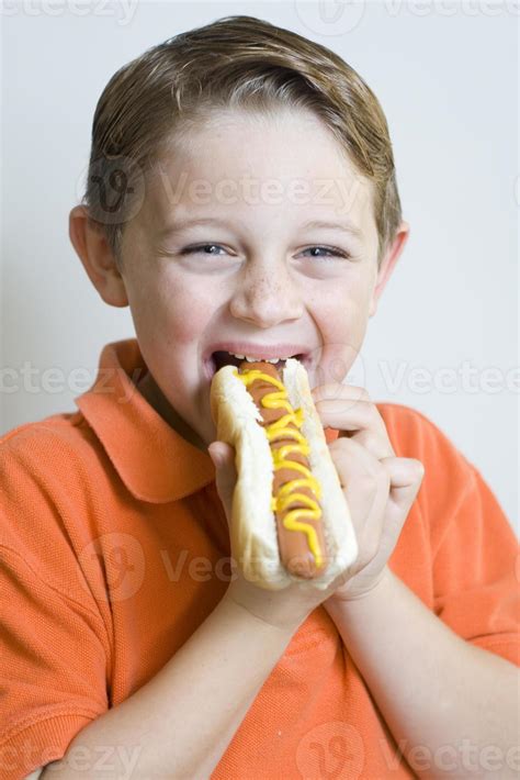 Young Boy Holding Eating Hot Dog 919483 Stock Photo at Vecteezy