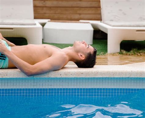 A Man Laying On The Edge Of A Swimming Pool