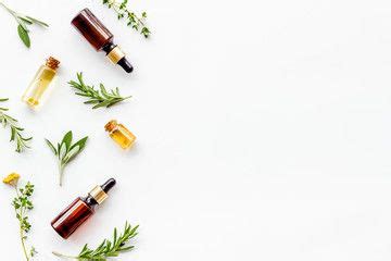 Natural Wellness Essential Oils Near Herbs And Leaves On White