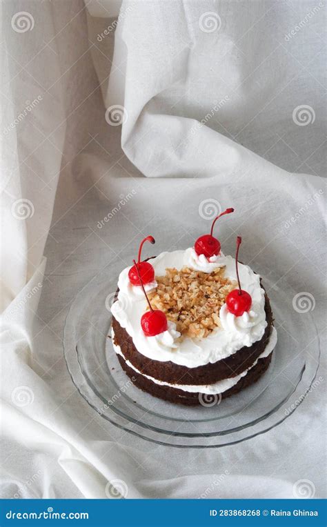 Chocolate Naked Cake With Cream Frosting And Decorated With Cherry And Peanut Stock Photo