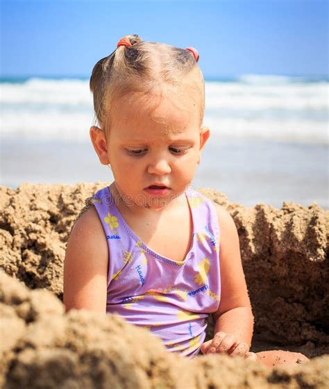 La Petite Fille Blonde S Assied Dans Des Jeux De Trou De Sable Sur La Plage Image Stock Image