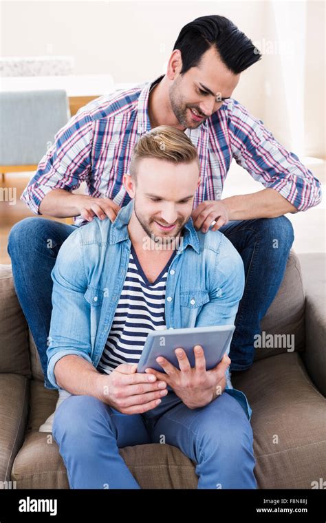 Gay Couple Relaxing On The Couch Using Tablet Stock Photo Alamy