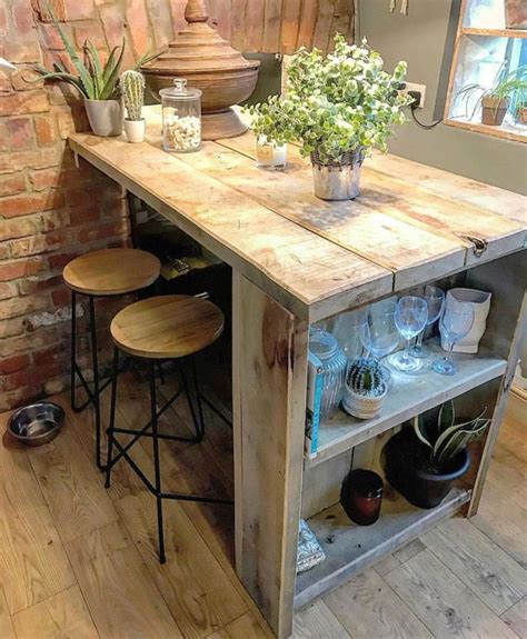 A Kitchen Island Made Out Of Pallet Wood With Stools And Potted Plants