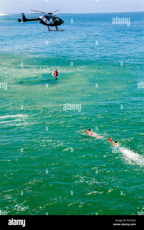 A City Helicopter Drops Rescue Personnel To Lifeguards In The Water To