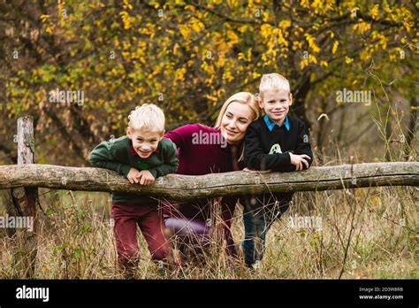 Preteen Twin Blonde Brothers Playing Outdoors With Happy Single Mom At Beautiful Warm Autumn