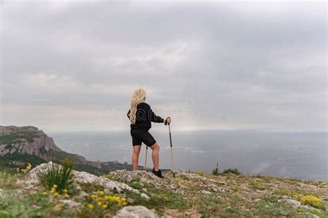 A Woman With Blonde Hair Is Standing On A Rocky Hillside Stock Image Image Of Active Climbing