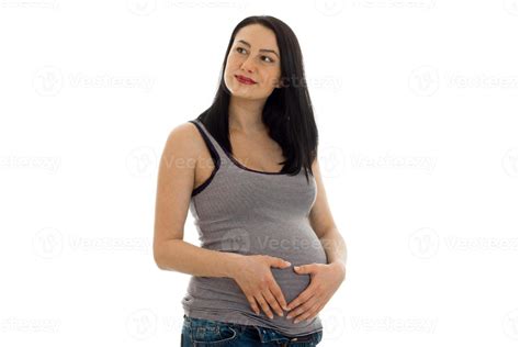 Lovely Brunette Pregnant Woman Touching Her Belly And Looking Away Isolated On White Background