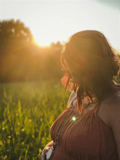 Woman In Brown Sleeveless Dress Standing On Green Grass Field During Sunset Photo Free Image