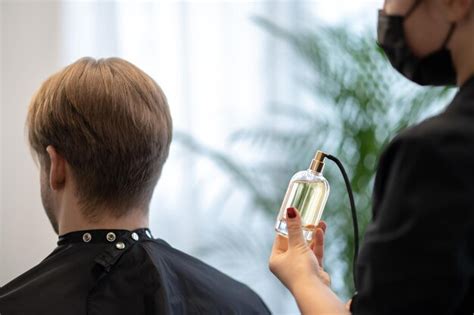 Premium Photo | Fragrance. Hairdresser spraying fragrance on the newly ...