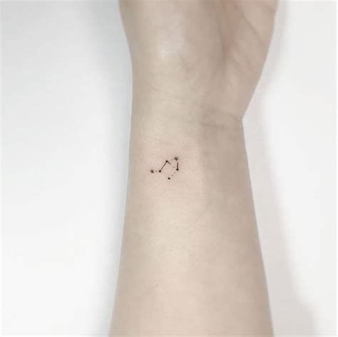 Libra constellation tattoo on the wrist.