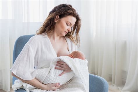 Mère Allaiter Son Bébé Assis Sur Un Fauteuil à La Maison Photo Premium