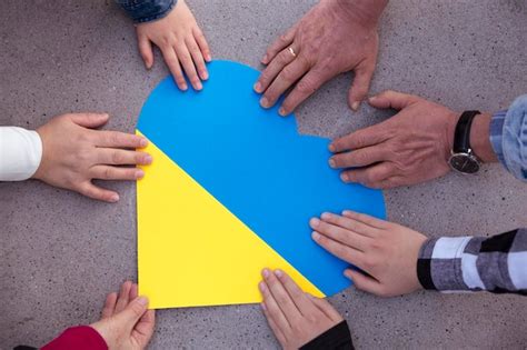 Mãos humanas em torno de um coração as cores da bandeira ucraniana