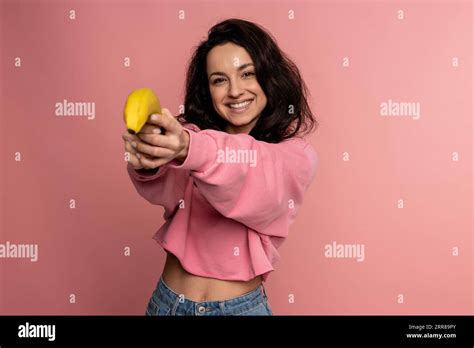 Cheerful Cute Brunette Posing During The Studio Photo Shoot On The Pink Background With Her