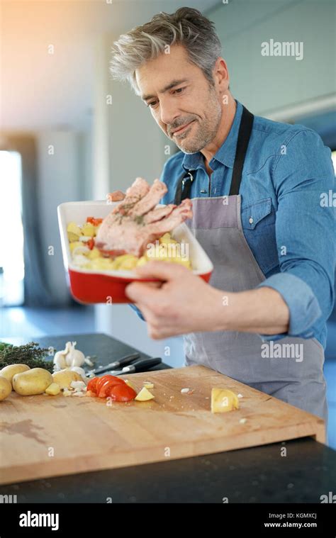 Mature Man In Kitchen Cooking Dish For Dinner Stock Photo Alamy