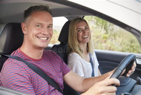 Retrato De Los Pares Maduros Que Se Sientan En Coche En Viaje Por