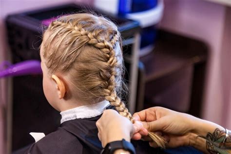 Barbière En Gros Plan Faire Des Tresses à La Mode Coiffure Pour Petite Fille Blonde Enfant Dans