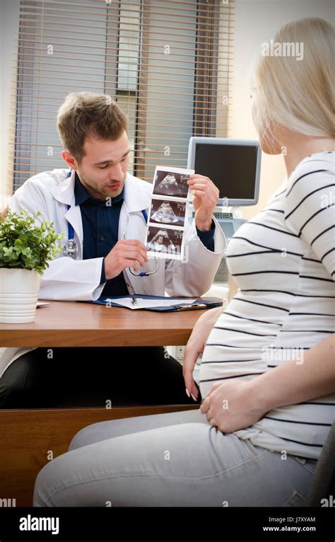 Doctor Showing Baby Ultrasound Image To Pregnant Woman Showing