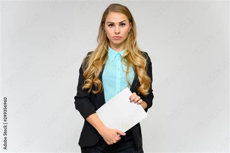 Portrait Of A Pretty Blonde Girl Financial Secretary With Long Curly Hair In A Business Suit