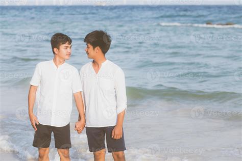 retrato homosexual joven pareja asiática de pie juntos en la playa en verano asia gay tomados