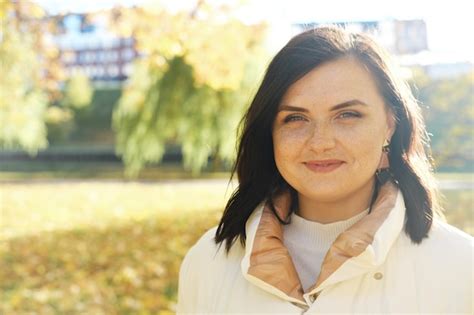 Premium Photo Beautiful Brunette Woman With Freckles On Her Face Smiles And Looks At The Camera