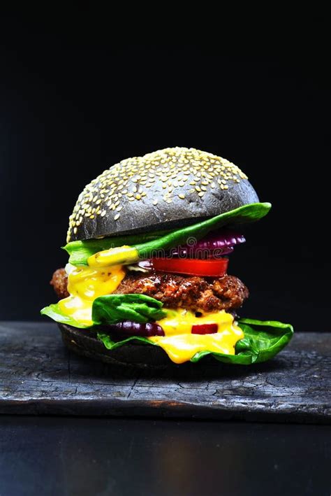 Black Beef Burger with Flowing Melted Cheese on a Black Background. Stock Photo - Image of ...