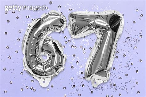 Silver Foil Balloon Number Digit Sixty Seven On A Lilac Background