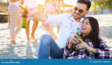 Cerveja Bebendo Dos Pares Novos Felizes E Divertimento Ter Na Praia