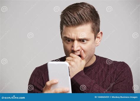 Portrait Of A Shocked Young White Man Using A Smartphone Stock Image