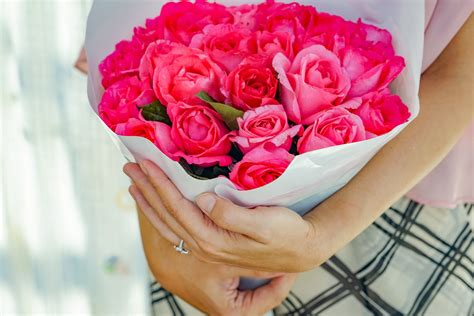 Photo of Woman's Hand Holding Out White Flowers In Front of White ...