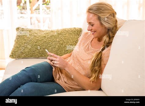 Pretty Blonde Using Smartphone On The Couch Stock Photo Alamy