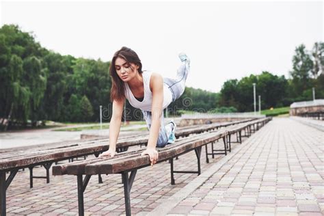 A Beautiful Athlete Brunette Performs Outdoor Exercises Stock Photo Image Of Grace Motion