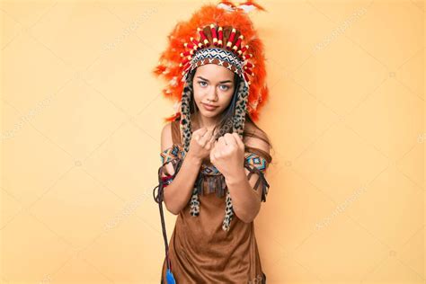 Joven chica latina hermosa con traje indio listo para luchar con el gesto de defensa del puño