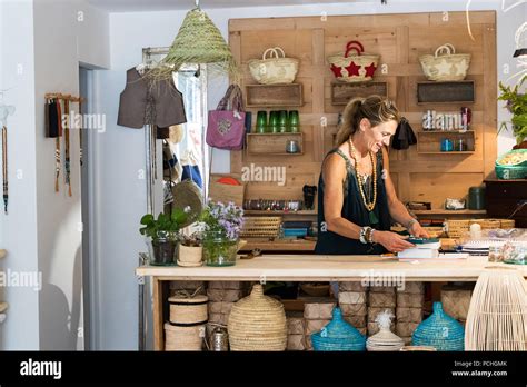 Portrait de femme mature blonde française travaillant heureux à son magasin de cadeaux faits