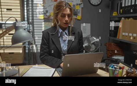 Focused Blonde Woman Working On Laptop In A Cluttered Detective Office Setting Showcasing