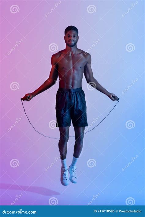Full Length Portrait Of Handsome Black Sportsman With Naked Torso Jumping On Skipping Rope In