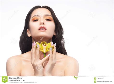 Uma Menina Moreno Bonita Dos Ombros Do Nude Guarda Sensualmente Um Flowe Imagem De Stock