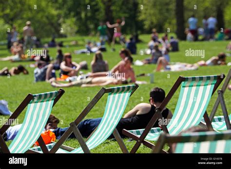 London Uk Th May Hot Summer Weather Brings People Out Sunbathing In Deckchairs In Green