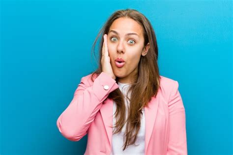 Premium Photo Young Woman Feeling Shocked And Astonished Holding Face To Hand In Disbelief