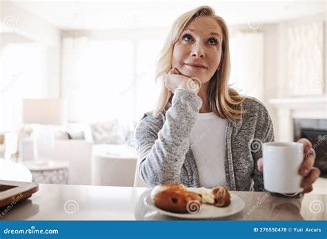What To Do Today A Mature Woman Having Coffee And A Snack During A Relaxed Day At Home Stock
