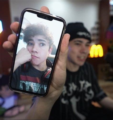 A Person Holding Up A Cell Phone With A Photo On It