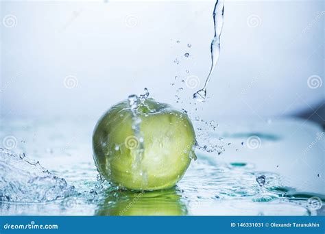 Manzana Verde Con El Chapoteo Freezed Del Agua Imagen De Archivo