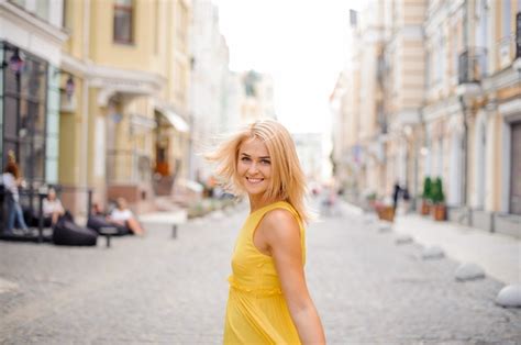 Premium Photo Beautiful Blonde Woman Dressed In A Yellow Dress Walking Around The City