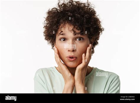 Shocked Curly Brunette Woman Expressing Surprise At Camera Isolated